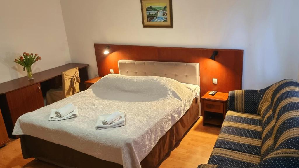 a hotel room with a bed and a chair at Restaurant & rooms Visovac - best value in Skradin