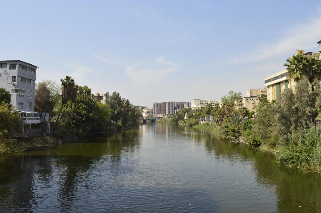 Nile Villa Hotel في القاهرة: نهر في مدينة بها مباني