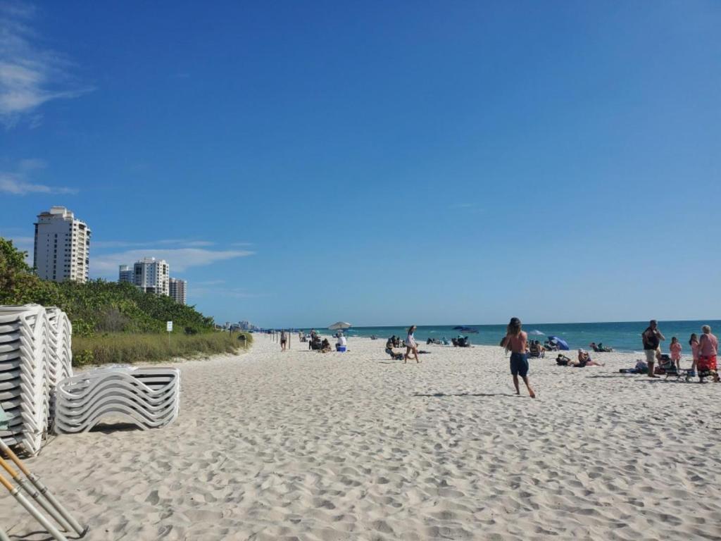 a group of people on a sandy beach at Few steps to Ocean-4 Beach Cruisers & Free parking & Private backyard in Jacksonville Beach