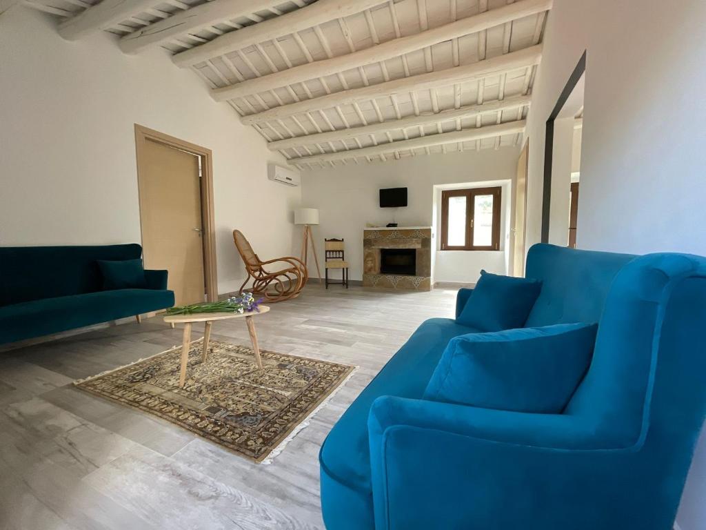 una sala de estar con sofás azules y una mesa. en Antico Borgo Buonanotte, en San Mauro Castelverde