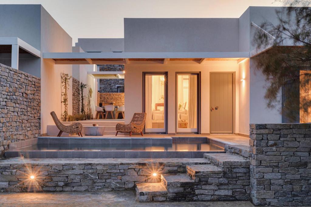 a house with a stone wall and a patio at SummerSalt Villa Paros in Molos Parou