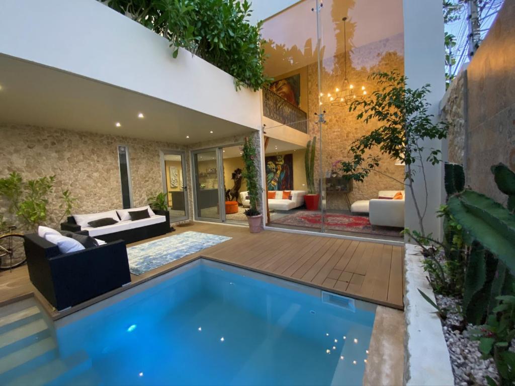 una casa con una piscina azul en el patio en Casarte Boutique Hotel en Playa del Carmen