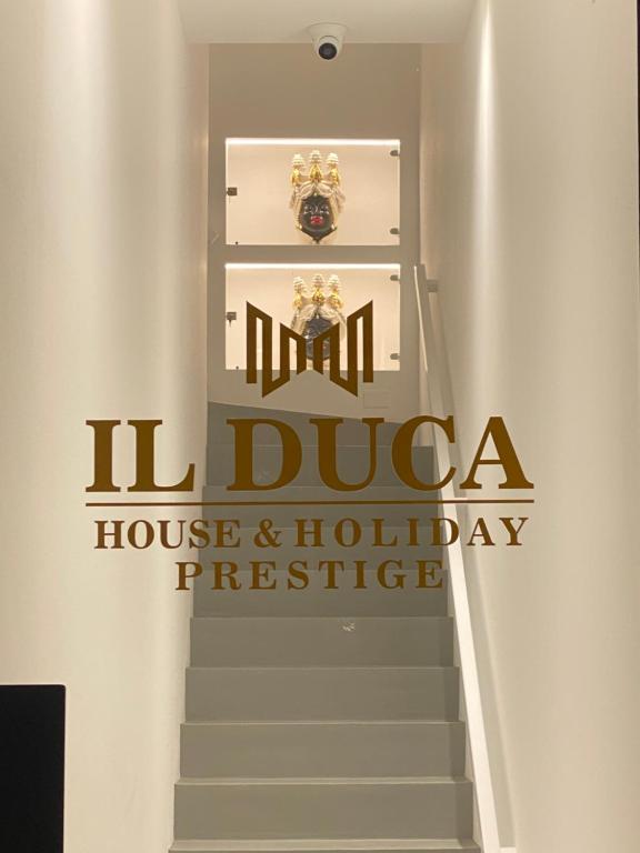 ein Schild für ein Haus und ein Ferienreservat auf einer Treppe in der Unterkunft IL DUCA HOUSE e HOLIDAY PRESTIGE in Caccamo