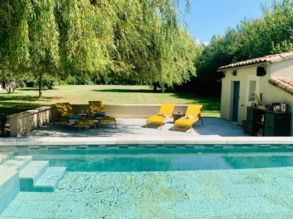 a group of chairs and a swimming pool at Mas des muses in LʼIsle-sur-la-Sorgue