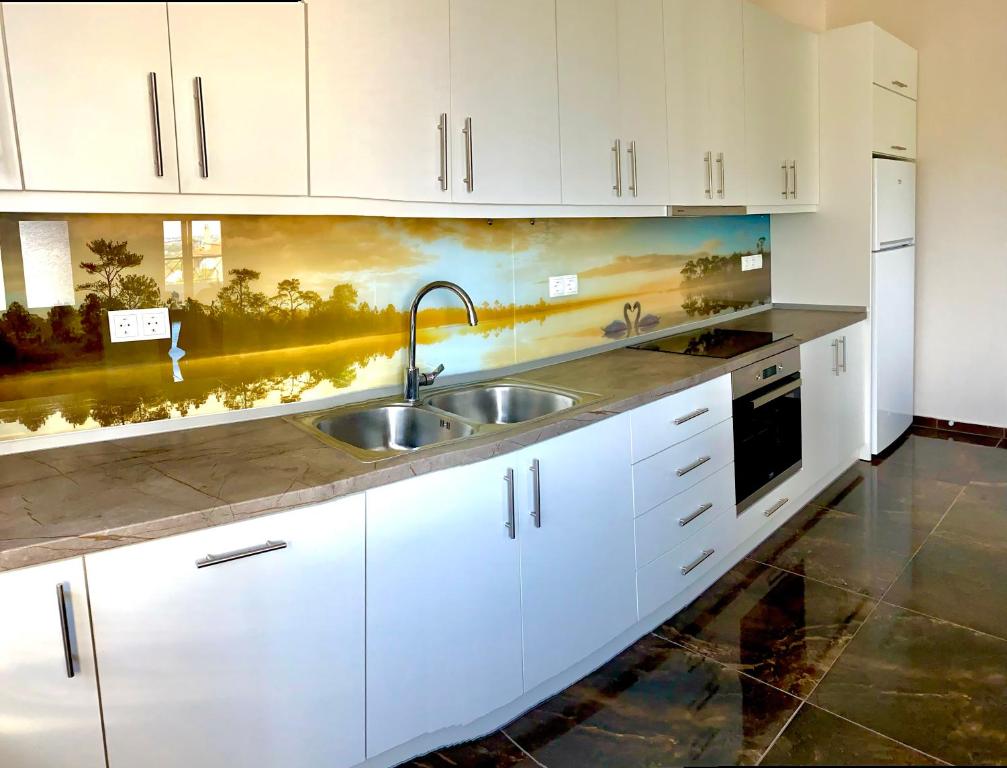 a kitchen with white cabinets and a sink at Natalie’s House in Alexandroupoli