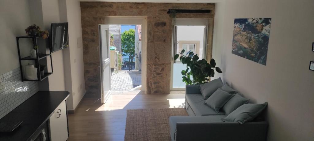 a living room with a couch and an open door at A Lobeira in Corcubión