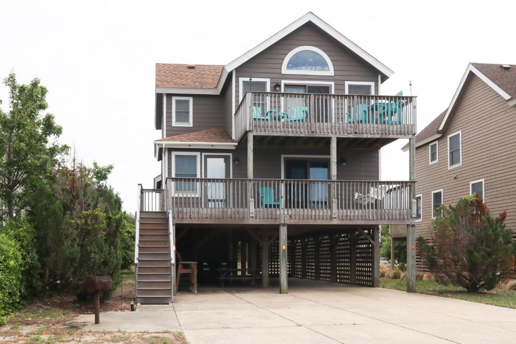 een groot huis met een terras en een balkon bij Gizmo's Getaway in Nags Head