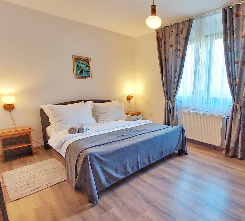 a bedroom with a large bed with a blue blanket at Lazy Bear in Plitvička Jezera