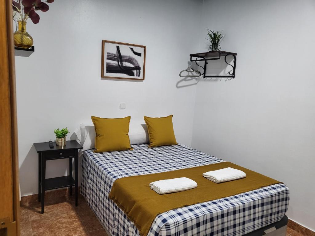 1 dormitorio con 1 cama con 2 toallas en M-A Catrachos Rooms, en Madrid