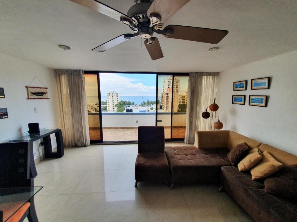 sala de estar con sofá y ventilador de techo en Acogedor apartamento con excelente vista al mar., en Santa Marta