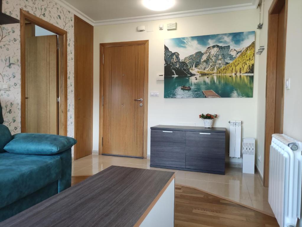 a living room with a couch and a painting on the wall at The Way Apartamento in O Pedrouzo