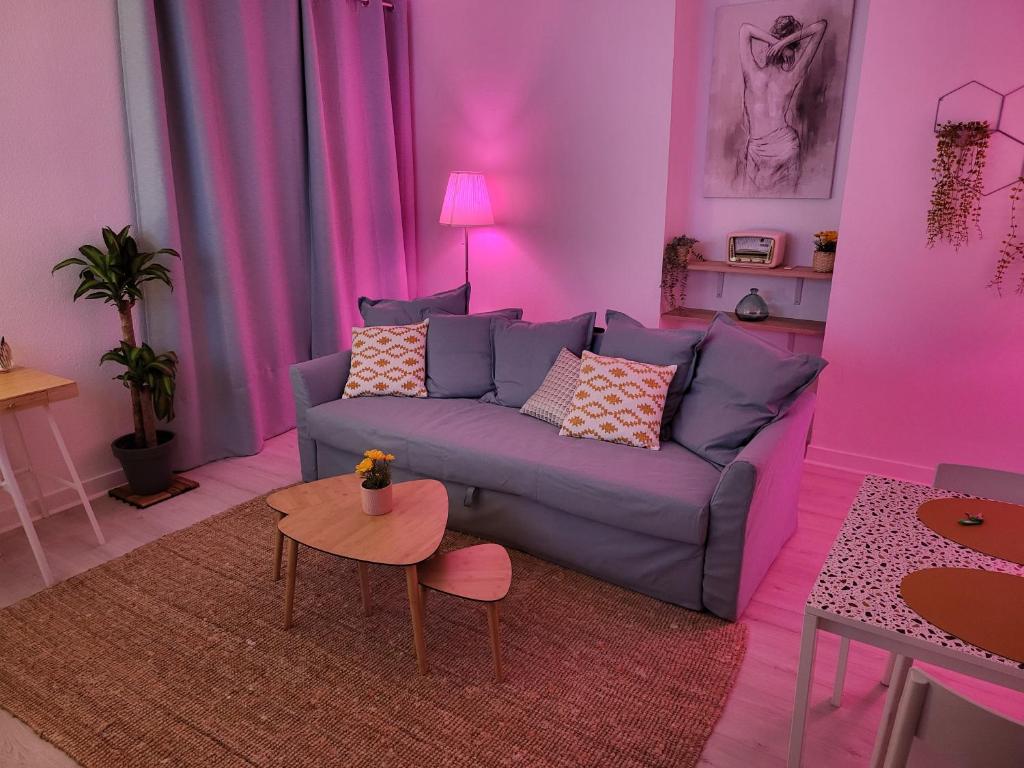 un soggiorno viola con divano e tavolo di Appartement zen et calme, centre ville a Vendôme