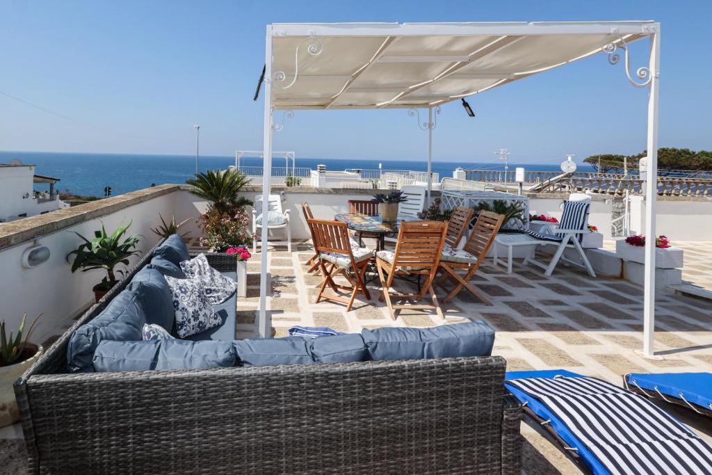 a patio with a couch and chairs and an umbrella at Villetta mare Salento in Patù