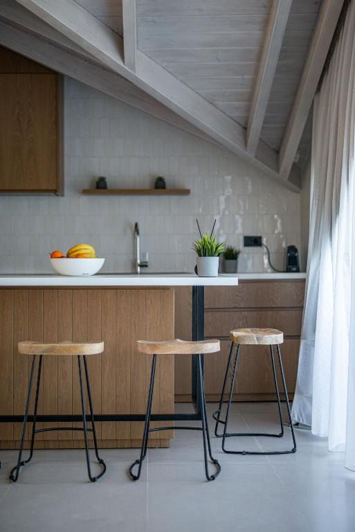 a kitchen with two bar stools and a counter at YOLO Resort - Loft in Alykes
