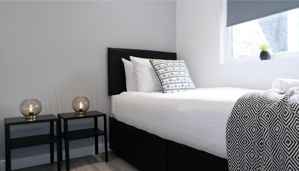 a bedroom with a large bed and two night stands at The Kop End Hotel by Serviced Living Liverpool in Liverpool