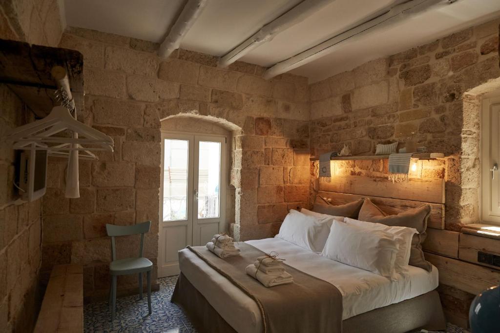 a bedroom with a large bed in a brick wall at Dei Serafini in Polignano a Mare
