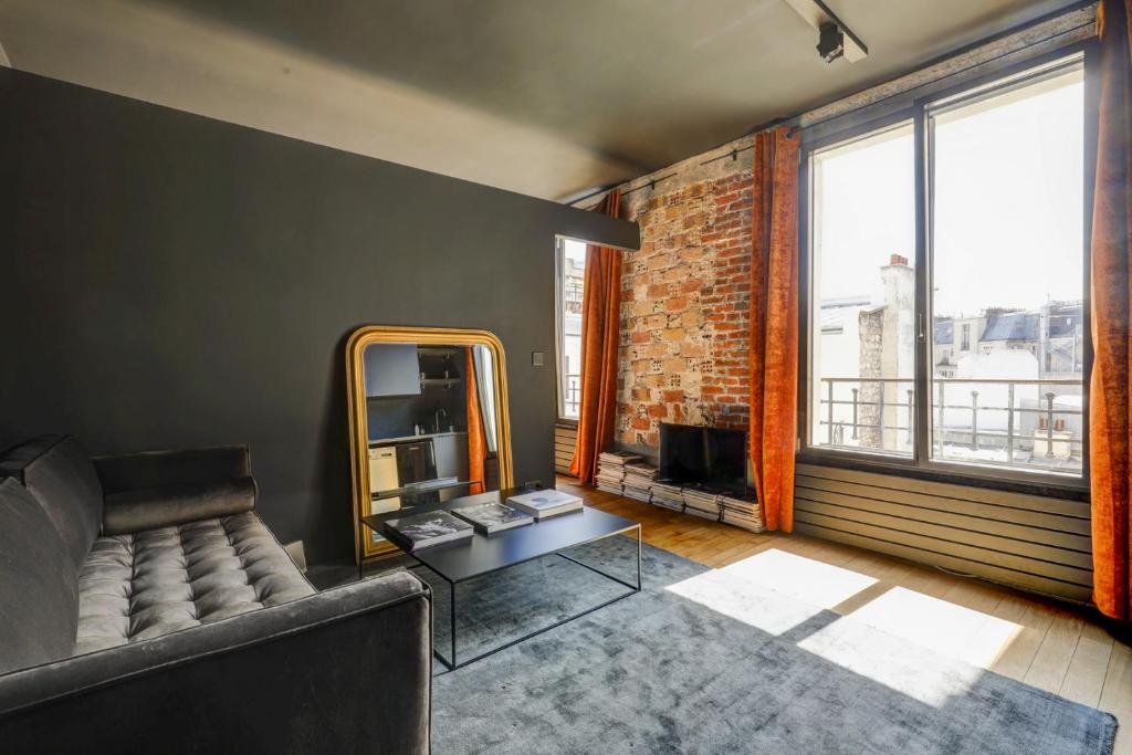 a living room with a couch and a mirror at Appartement artiste atelier bail mobilité Palais Royal in Paris