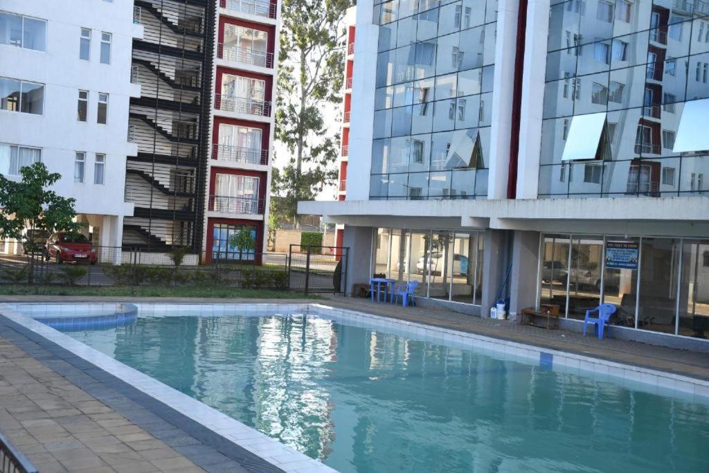 una piscina vacía frente a un edificio en Delightful Studio,Racecourse Gardens Apt with pool, en Nairobi