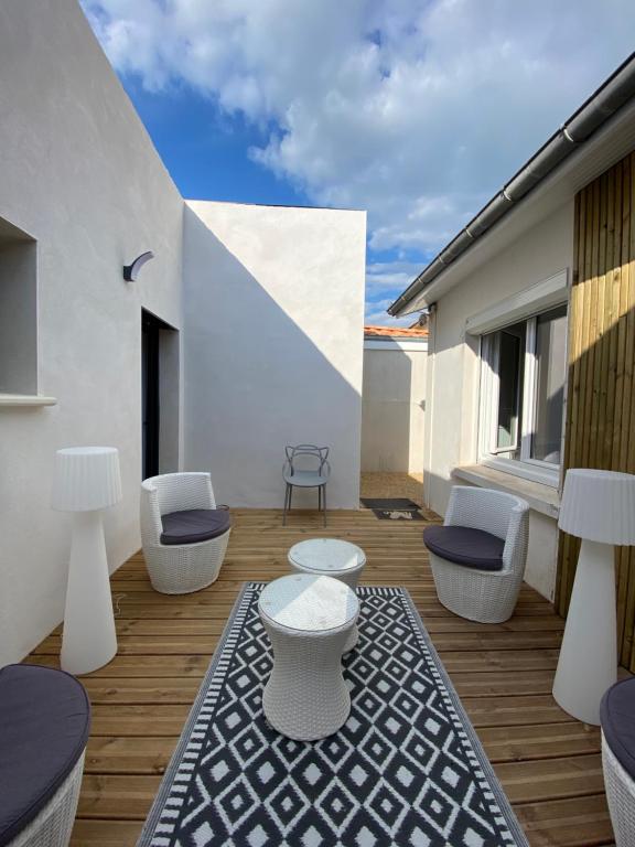 un patio avec deux chaises et une table sur un balcon dans l'établissement Calme et ensoleillée Maison au pied de la plage entre St Palais sur Mer et Royan, à Vaux-sur-Mer