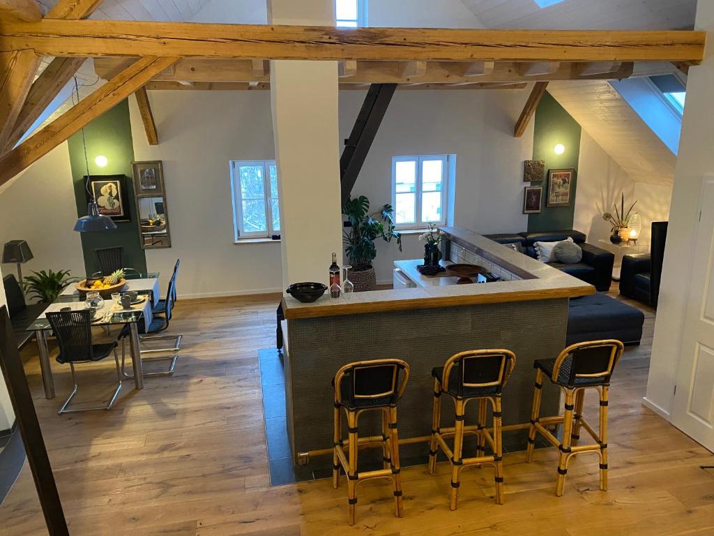 uma cozinha e sala de estar com um balcão e cadeiras em Ferienwohnung d.d. Chalet em Aitrach
