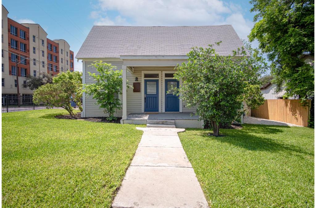 a small house with a blue door in a yard at Incredible New 3BR2BA Near Downtown in San Antonio