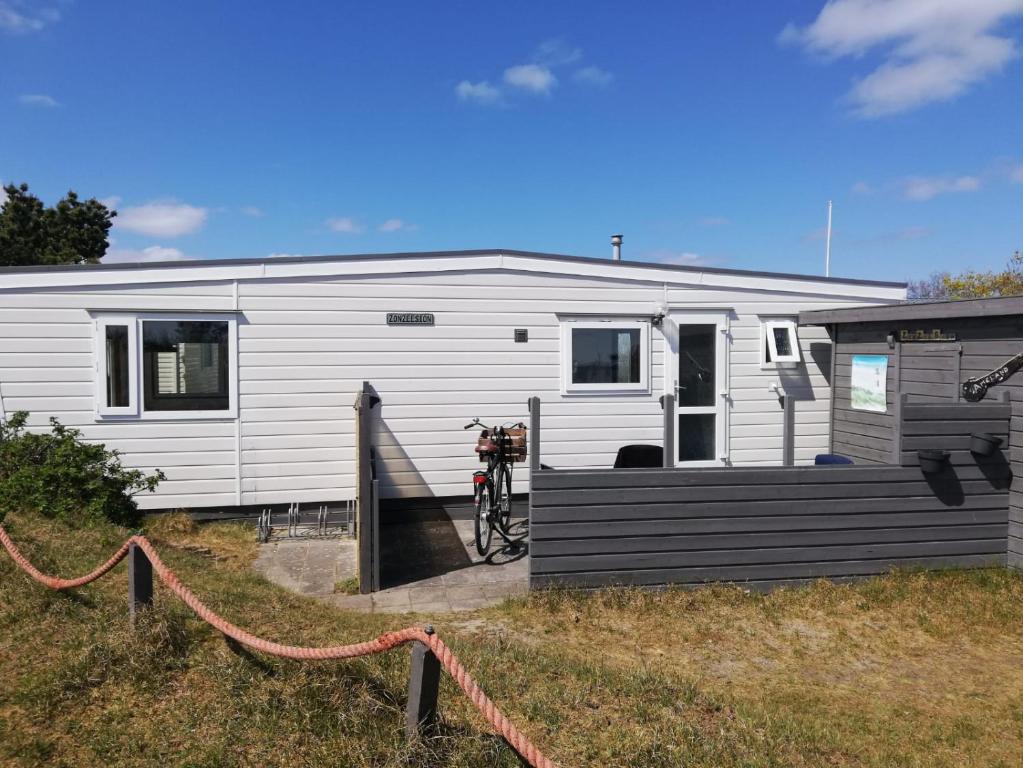 a white trailer with a bike parked in front of it at Chalet ZonZeeSion T12 with Bikes! in Buren