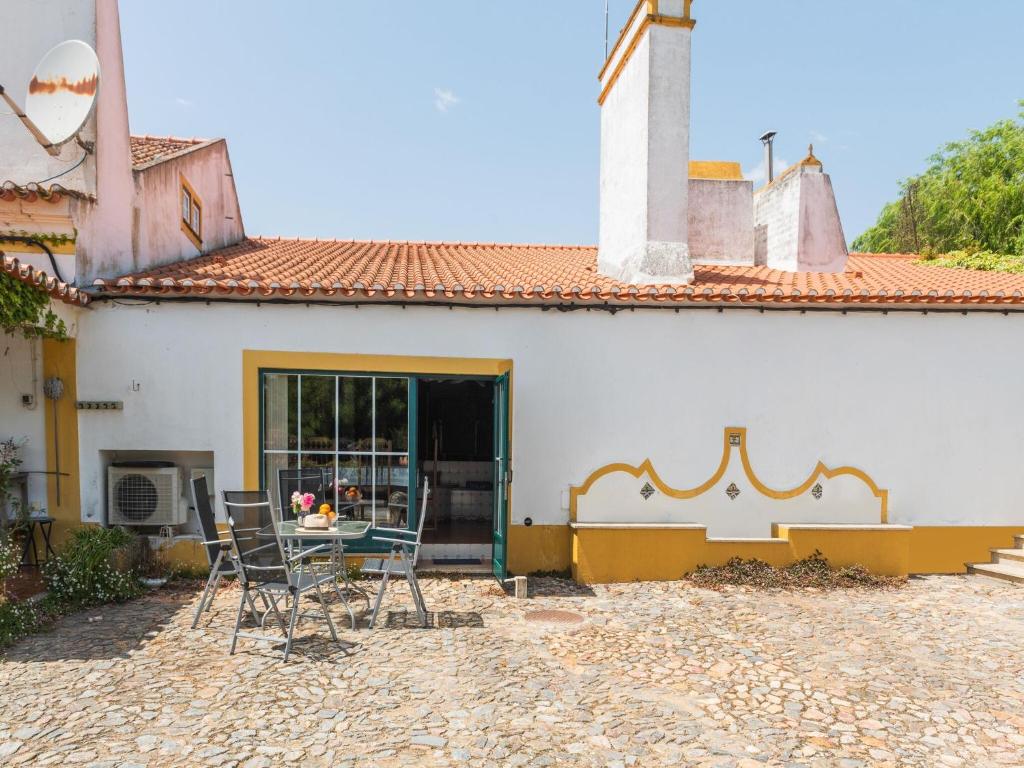 a table and chairs in front of a house at Farmhouse in Montemor near Forest and Lake in Montemor-o-Novo