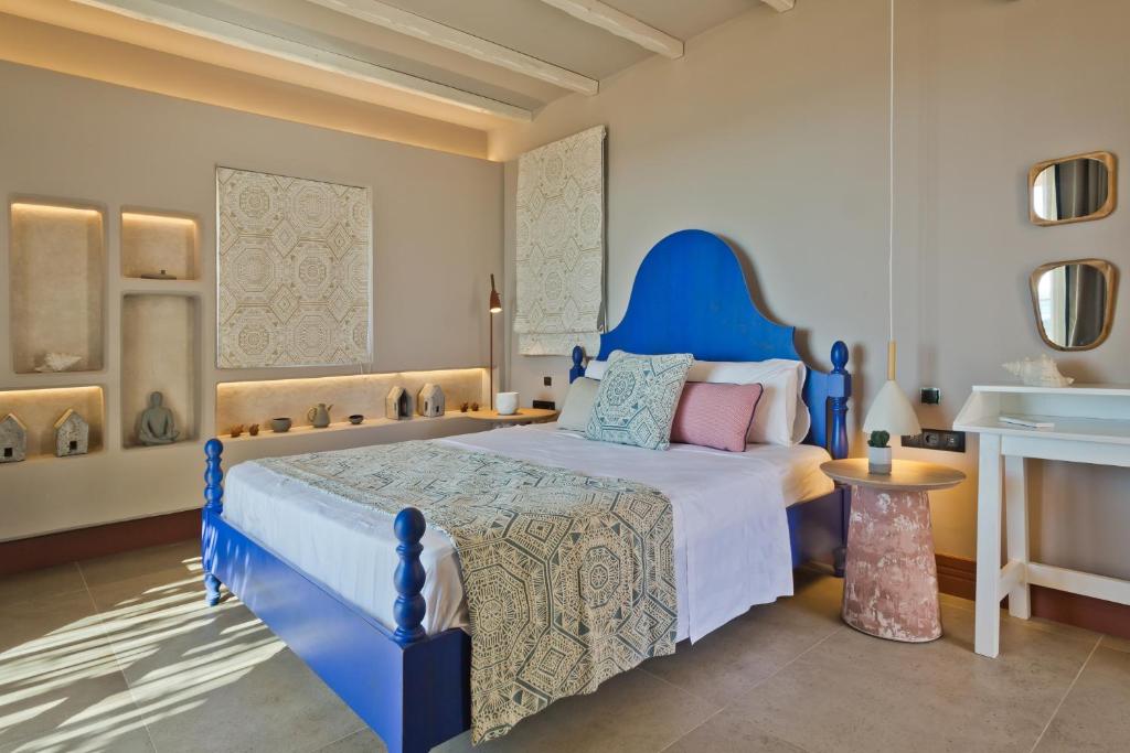 ein Schlafzimmer mit einem blauen Bett in einem Zimmer in der Unterkunft Amoopi Nymfes Royal in Amoopi