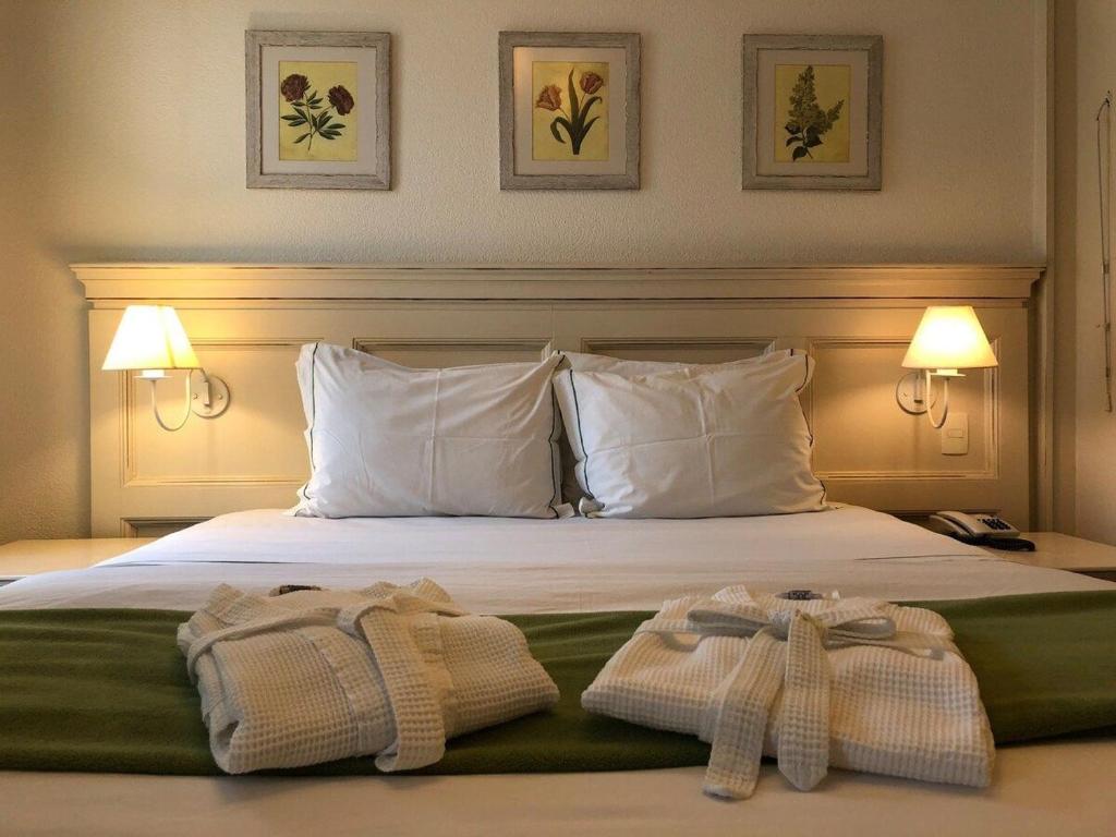 una camera d'albergo con un letto e due asciugamani di Il Campanário Jurerê Internacional - Studio a Florianópolis