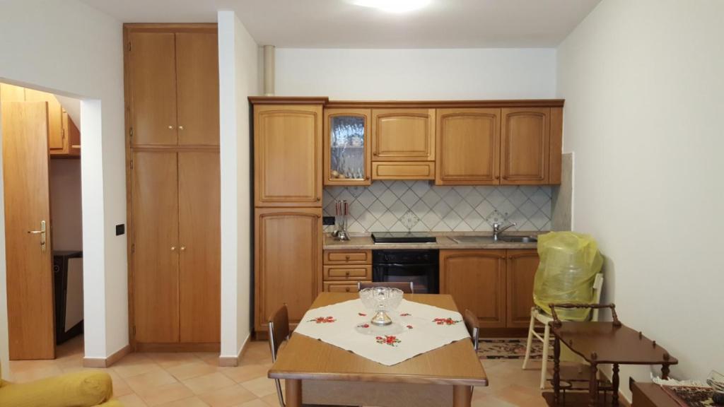 a kitchen with wooden cabinets and a table in it at La casetta de la Rocca in Gualdo Tadino