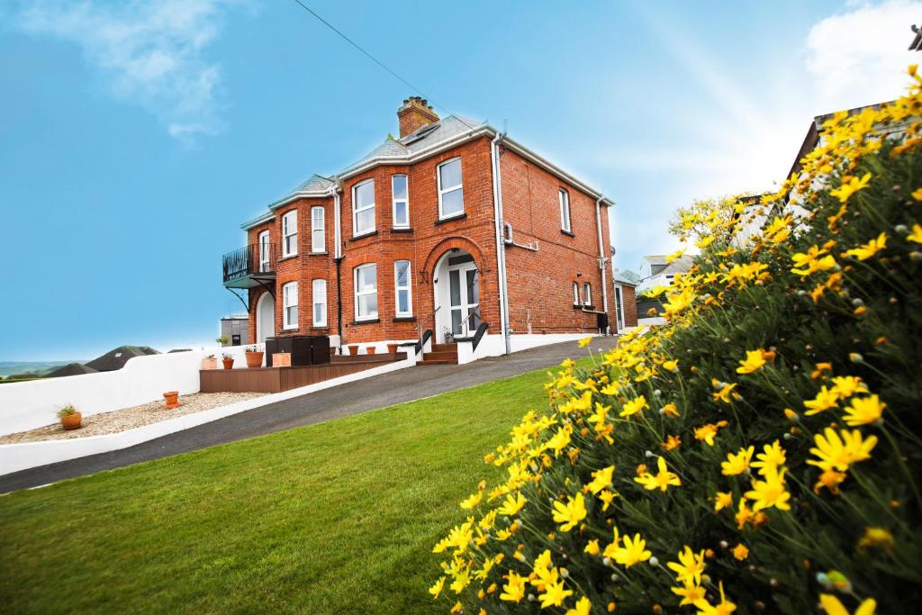 a brick building with yellow flowers in front of it at No 10 Treverbyn Road in Padstow