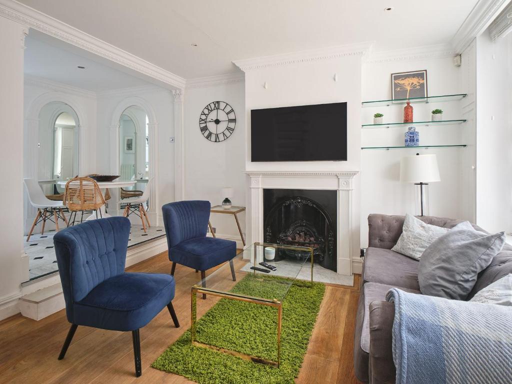 ein Wohnzimmer mit einem Sofa und einem Kamin in der Unterkunft Stylish 3 bedroom town house in London