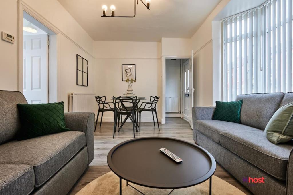 a living room with two couches and a table at Host Liverpool - Family Home Near Centre, Pets OK & Free Parking in Liverpool