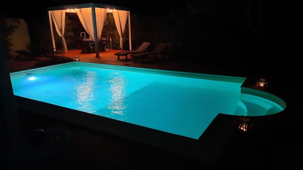 a swimming pool lit up at night at Villa Kuky in Santa Teresa Gallura