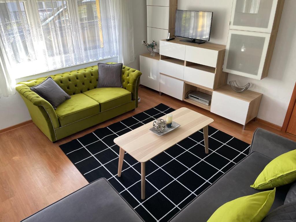 a living room with a green couch and a coffee table at Apartament 2 pokoje 45m2 - 200 metrów od morza in Międzyzdroje