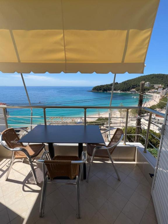 a table and chairs on a balcony with a view of the ocean at Fane's Apartments in Himare