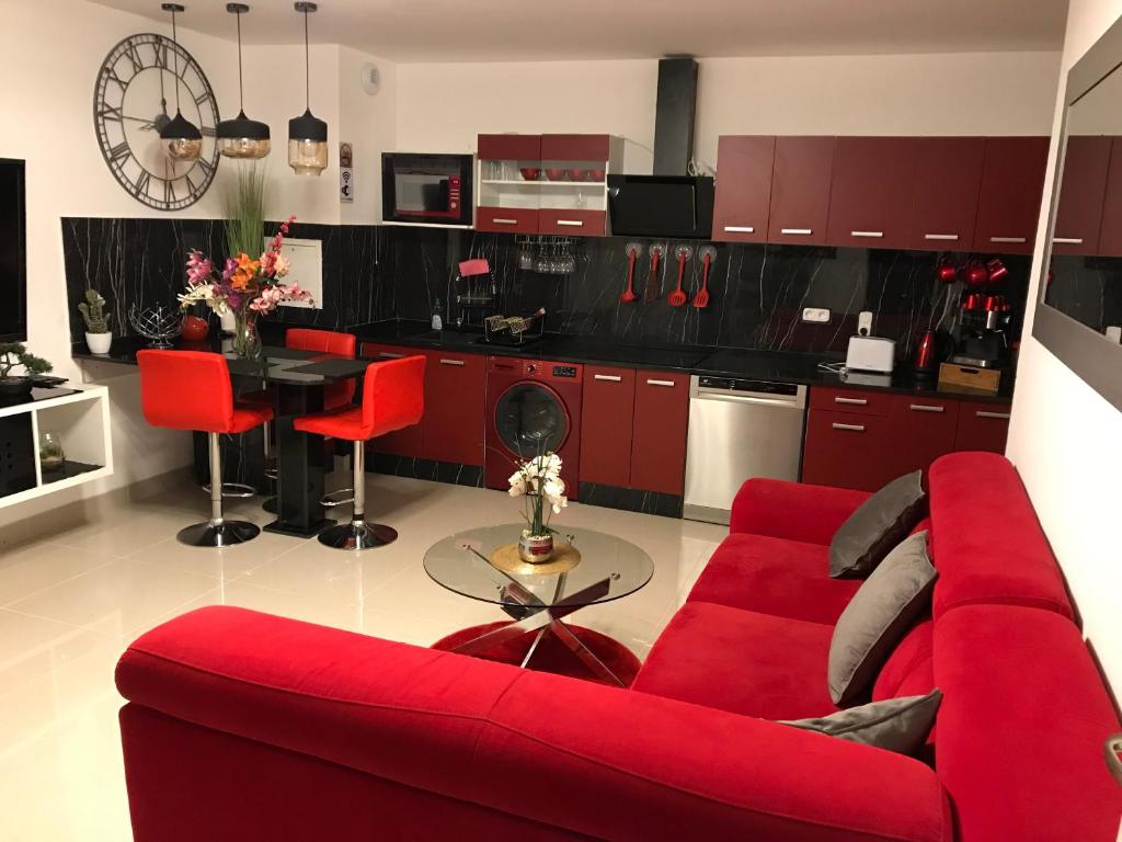 ein Wohnzimmer mit einem roten Sofa und einem Tisch in der Unterkunft Sandy Eden Superieur in Drancy