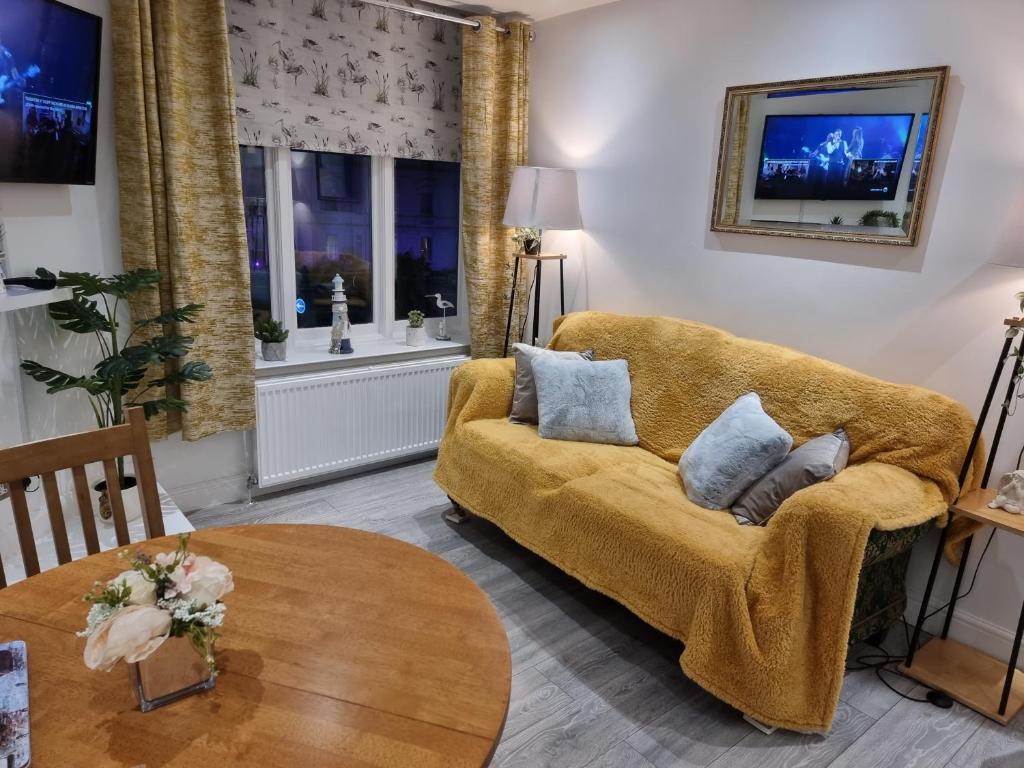 a living room with a couch and a table at 3 Minute Walk to Beach - Couldn't be much closer to sea in Bournemouth