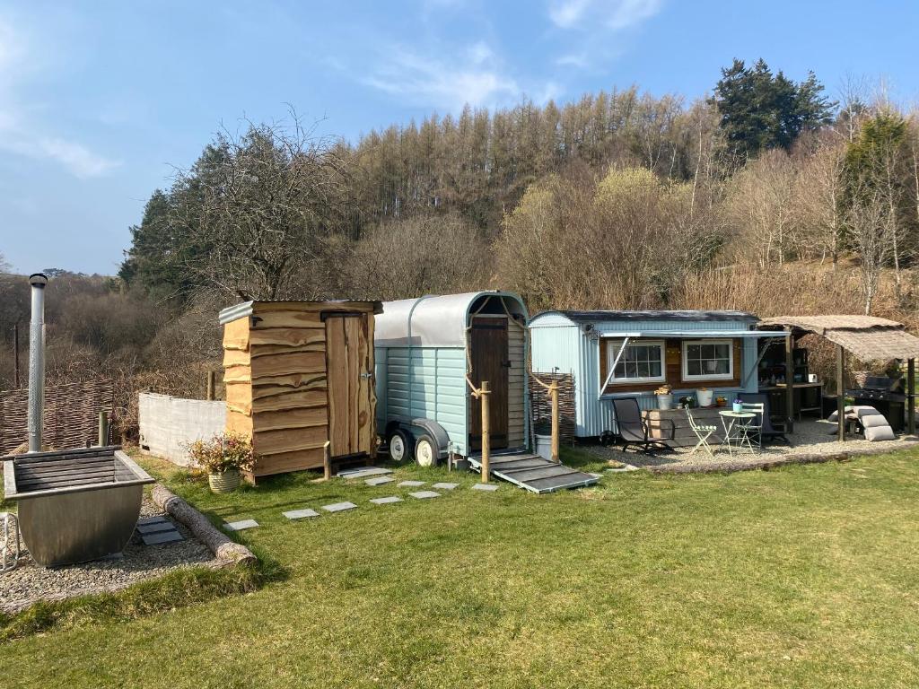 an rv and a shed sitting in a yard at Belan Bluebell Woods Shepherds Hut in Llanidloes