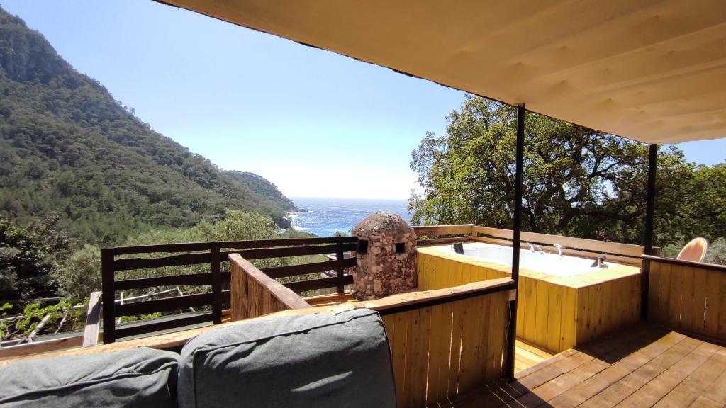 a hot tub on a deck with a view of a mountain at Kabak Lost Forest VİLLA in Kızılcakaya