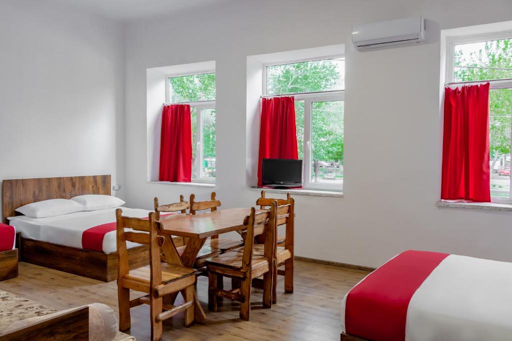a bedroom with two beds and a table and chairs at Family Appartments on Buzand street in Yerevan