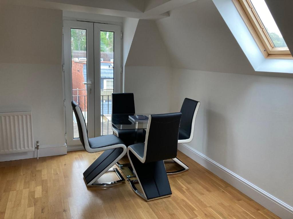 una oficina con dos sillas y una mesa de cristal en Letting Serviced Apartments - Chorleywood Village, en Chorleywood