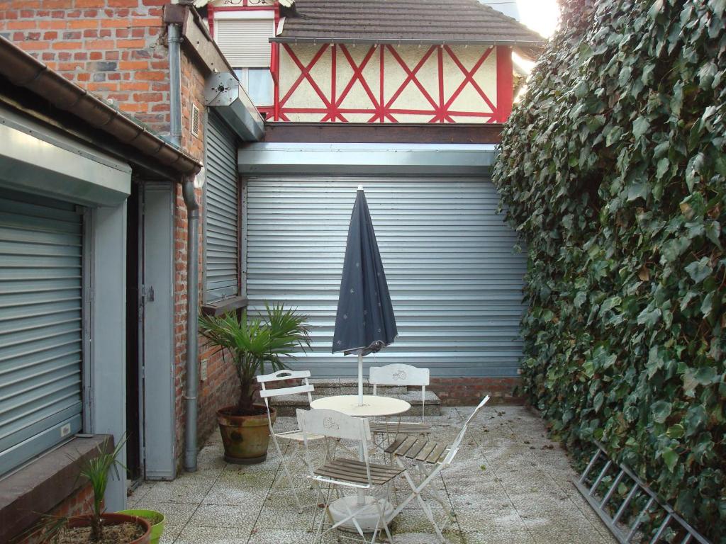 einen Tisch und Stühle mit Sonnenschirm auf einer Terrasse in der Unterkunft Chalet appartement in Lille