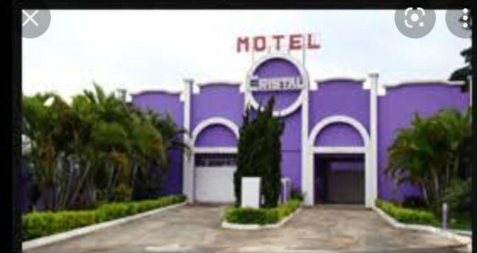 a purple building with a hotel sign on it at Motel Cristal in Araras