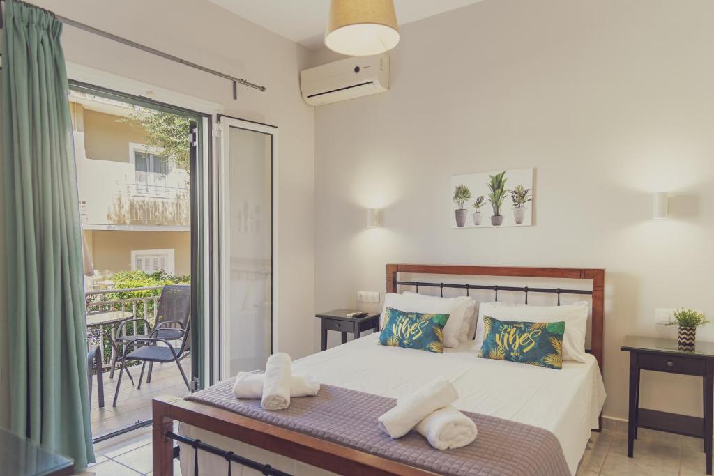 a bedroom with a bed and a balcony at Maria Olga Apartments in Benitses