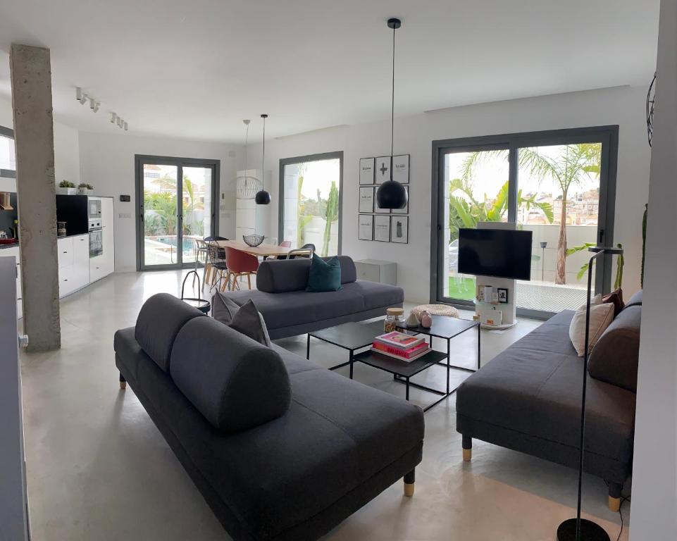 un salon avec deux canapés et une télévision dans l'établissement EBLICórner S, à San Miguel de Salinas