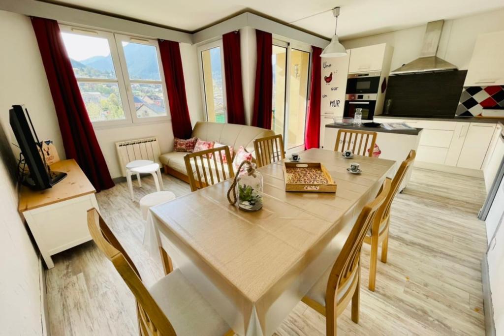 een keuken en eetkamer met een tafel en stoelen bij Bright 50 M With Balcony And View On The Valley in Briançon