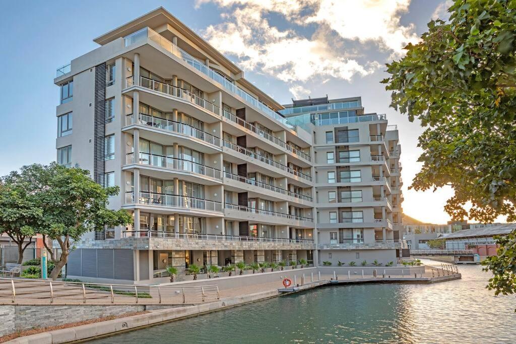 a large apartment building next to a body of water at Canal Quays 606 in Cape Town