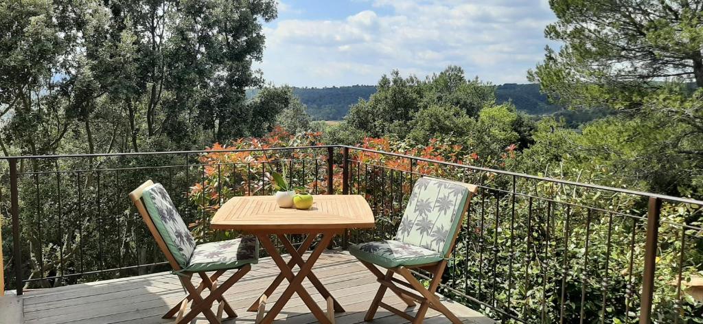 a wooden table and two chairs on a deck at Au Papillon Dort in Seillons-Source-dʼArgens