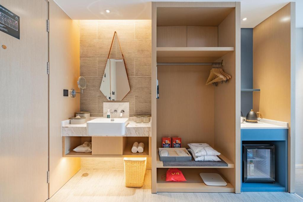 un baño con lavabo y espejo en Atour Hotel Hangzhou Qianjiang Century Zhenning Road, en Xiaoshan